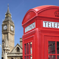 Traditional red telephone box with Big Ben out of focus in the background.